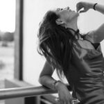 Stylish black and white portrait of a woman in a dress outdoors, exuding elegance and confidence.